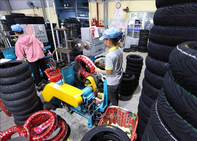 Hoàn thiện sản phẩm lốp xe máy trước khi xuất xưởng ở nhà máy của Công ty TNHH Cao su CAMEL Việt Nam, 100% vốn Thái Lan tại khu kinh tế cửa khẩu quốc tế Lao Bảo, tỉnh Quảng Trị. Ảnh: Vũ Sinh - TTXVN