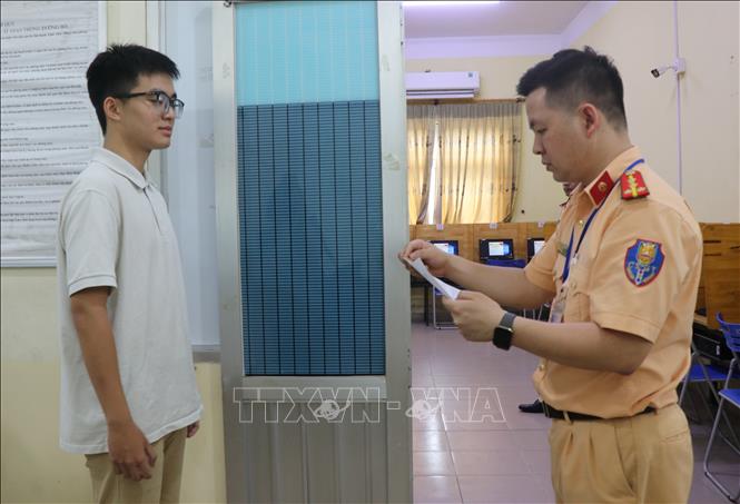 Cán bộ Phòng Cảnh sát Giao thông (Công an tỉnh Bắc Ninh) kiểm tra hồ sơ và hướng dẫn học viên tham gia phần thi lý thuyết. Ảnh: Thanh Thương- TTXVN
