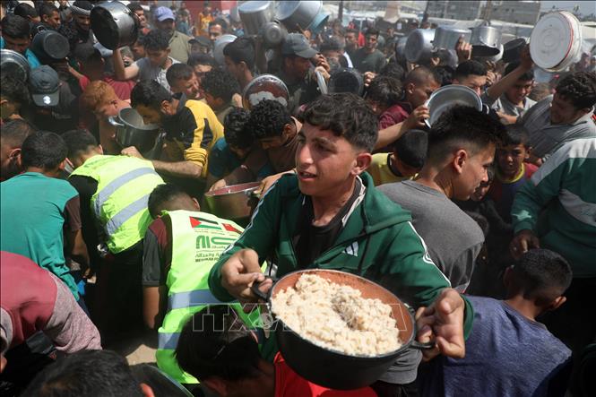 Người dân được phát thực phẩm cứu trợ tại Gaza. Ảnh: THX/TTXVN