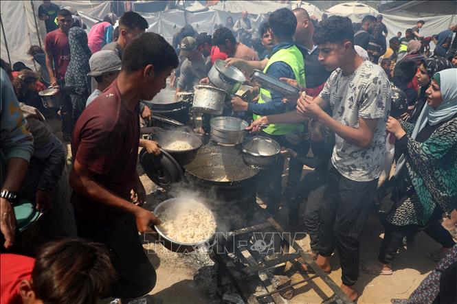 Tình nguyện viên phân phát thực phẩm cứu trợ cho người dân tại Gaza. Ảnh: THX/TTXVN