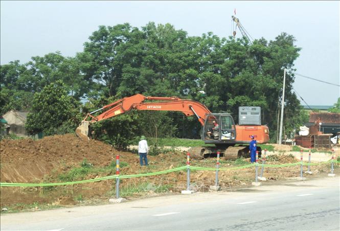 San ủi mặt bằng, di dời các công trình hạ tầng kỹ thuật điện chiếu sáng, cây xanh, hạ tầng viễn thông, đường ống cấp nước sinh hoạt…để sớm bàn giao mặt bằng cho nhà thầu. Ảnh: Xuân Tiến - TTXVN 