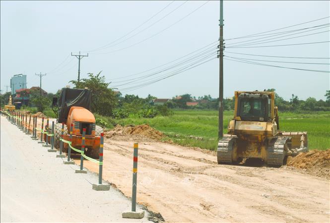 Nhà thầu huy động nhân lực, máy móc thi công các hạng mục đào, đắp nền đường trong phạm vi mặt bằng được bàn giao. Ảnh: Xuân Tiến - TTXVN 