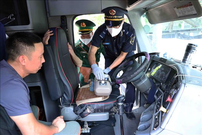 Nhân viên Hải quan phối hợp với lực lượng Biên phòng ở cửa khẩu quốc tế Lao Bảo, tỉnh Quảng Trị, kiểm tra chất ma tuý đối với phương tiện và lái xe nhập cảnh bằng thiết bị máy soi cầm tay. Ảnh: Vũ Sinh - TTXVN