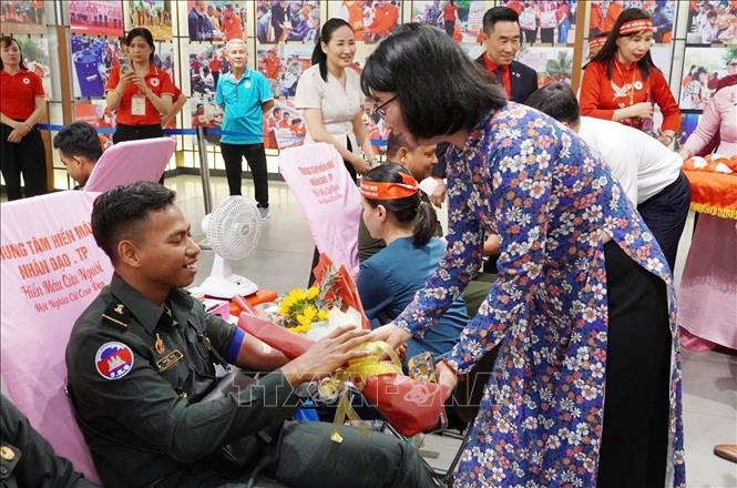 Bà Trần Thị Diệu Thuý, Phó Chủ tịch UBND Thành phố Hồ Chí Minh, tặng hoa cho học viên Campuchia tại Trường Sỹ quan Công binh tham gia hiến máu tình nguyện. Ảnh: Thu Hương – TTXVN