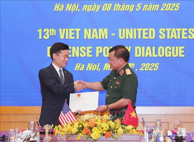  Thượng tướng Hoàng Xuân Chiến, Thứ trưởng Bộ Quốc phòng và  Quyền Trợ lý Bộ trưởng Quốc phòng Hoa Kỳ John Noh trao đổi kỷ vật của binh sĩ hai nước tìm được sau chiến tranh. Ảnh: Trọng Đức - TTXVN