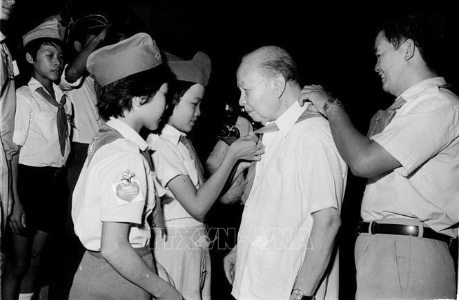 Các đại biểu Cháu ngoan Bác Hồ quàng khăn đỏ cho Chủ tịch Hội đồng nhà nước Trường Chinh đến dự Đại hội Cháu ngoan Bác Hồ toàn quốc lần thứ II (4/7/1985). Ảnh: Trần Ấm - TTXVN