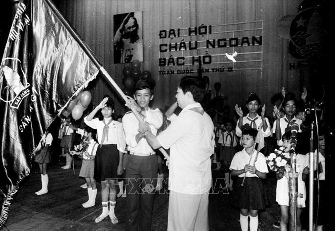 Bí thư thứ nhất BCH TW Đoàn TNCS HCM trao lá cờ danh dự của đội mở đầu cho cuộc hành quân theo chân Bác trong lễ khai mạc Đại hội Cháu ngoan Bác Hồ toàn quốc lần thứ II (4/7/1986). ẢNh: Trần Tuấn - TTXVN