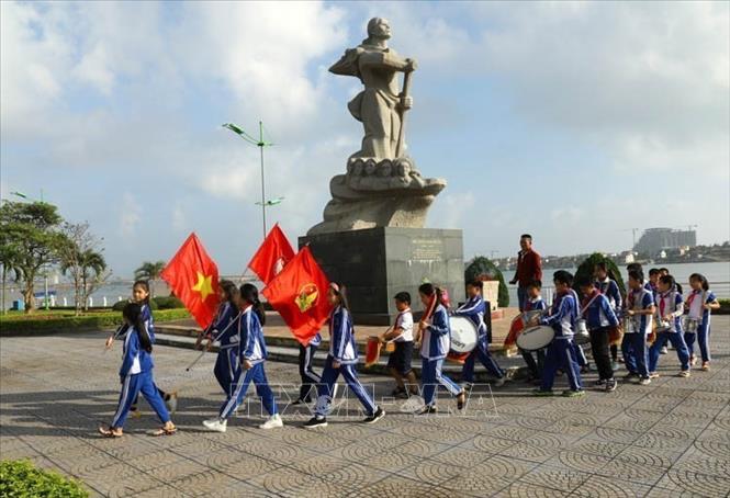 Lễ kết nạp đội viên Đội Thiếu niên Tiền phong Hồ Chí Minh của trường Tiểu học Hải Đình (thành phố Đồng Hới, tỉnh Quảng Bình) diễn ra trang trọng, đúng nghi thức dưới chân tượng đài Mẹ Suốt Anh hùng. Ảnh: Ngọc Hà - TTXVN
