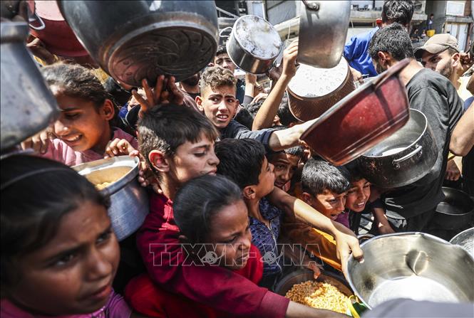 Người dân Palestine nhận thức ăn cứu trợ tại thành phố Gaza ngày 3/5/2025. Ảnh: THX/TTXVN