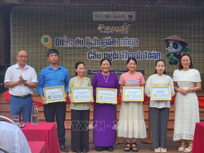 Trao chứng nhận cho các cơ sở thí điểm mô hình giảm nhựa tại Điểm du lịch giảm nhựa Cầu ngói Thanh Toàn. Ảnh: Mai Trang - TTXVN 