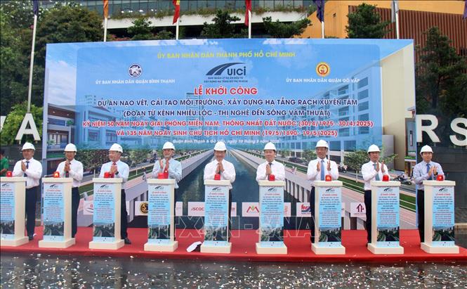 Các đại biểu thực hiện nghi thức khởi công dự án nạo vét, cải tạo rạch Xuyên Tâm. Ảnh: Tiến Lực - TTXVN