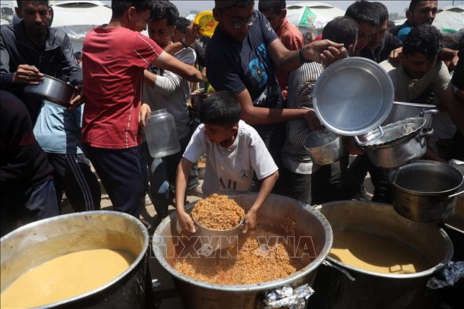 Người dân Palestine nhận thức ăn cứu trợ tại thành phố Gaza ngày 9/5/2025. Ảnh: THX/TTXVN