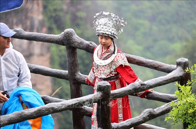 Em bé người dân tộc tạo dáng, chụp lại những khoảnh khắc đáng nhớ ở Vũ Lăng Nguyên. Ảnh: Quang Hưng - TTXVN tại Trung Quốc