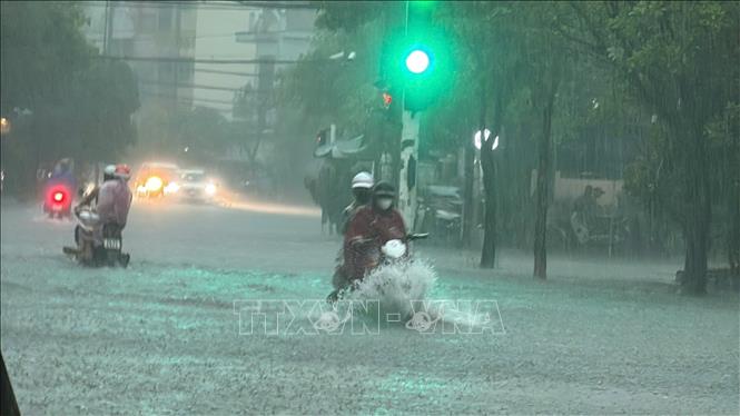 Mưa lớn khiến các phương tiện lưu thông trên đường Trần Quang Khải (thành phố Đồng Hới) gặp nhiều khó khăn. Ảnh: TTXVN phát