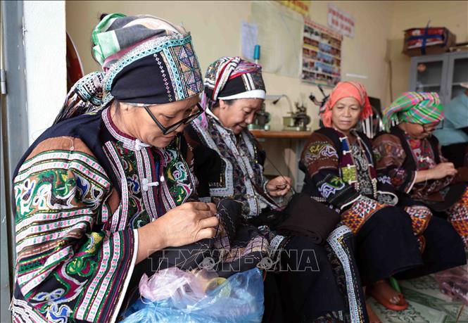 Lo Lo women skillfully embroider floral patterns on traditional attire. VNA Photo: Trần Việt