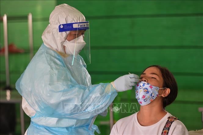 Nhân viên y tế lấy mẫu xét nghiệm COVID-19 cho người dân tại Bangkok, Thái Lan. Ảnh: THX/TTXVN