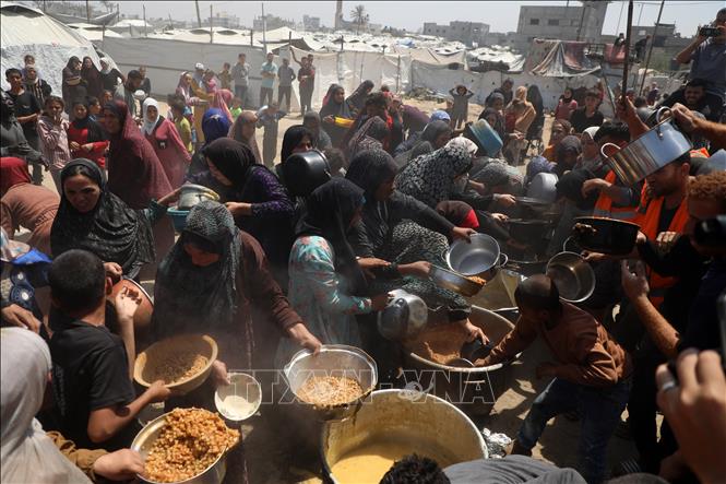 Người dân Palestine nhận thực phẩm cứu trợ tại Gaza. Ảnh: THX/TTXVN