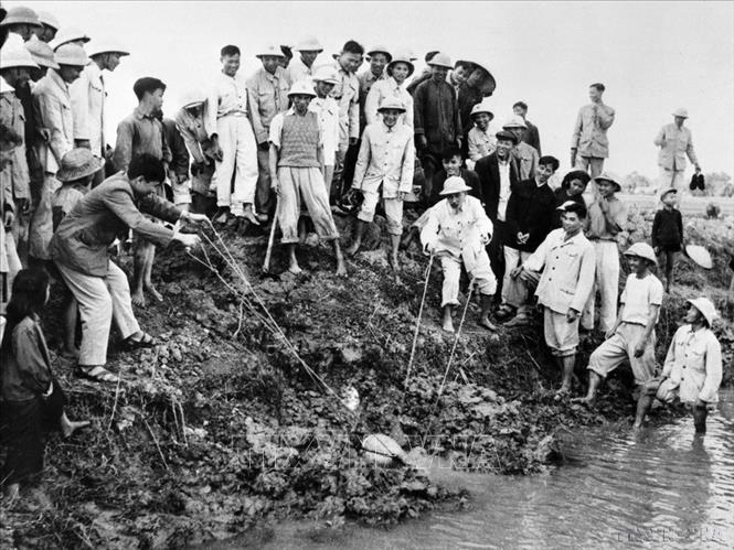 Chủ tịch Hồ Chí Minh tát nước chống hạn với bà con nông dân xã Đại Thanh, tỉnh Hà Đông (nay là Hà Nội) ngày 12/1/1958. Ảnh: Đinh Đăng Định - TTXVN
