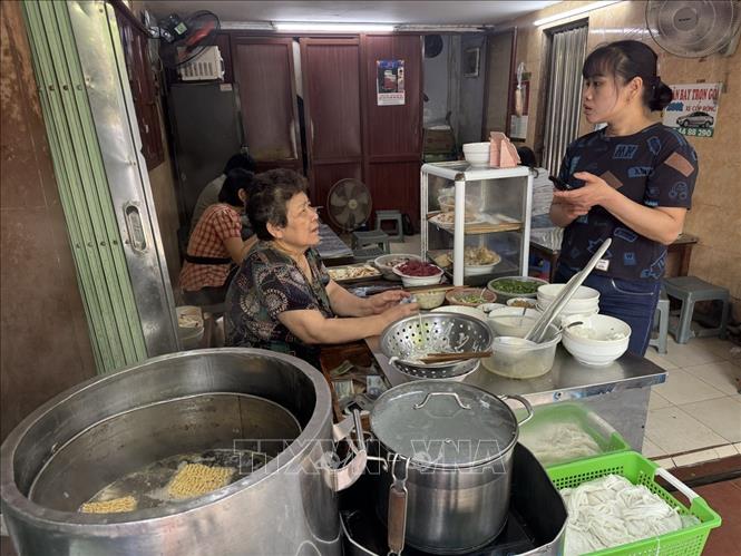 Chủ cửa hàng phở tại Phố Nguyễn Du cho biết chi phí đầu vào, giá nguyên vật liệu và giá điện tăng nên phải tính toán, điều chỉnh lại giá bán. Ảnh: Quốc Lũy - TTXVN