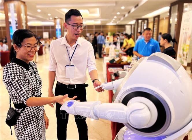 Các đại biểu tương tác với robot trưng bày tại Hội thảo “Phát triển nguồn nhân lực khoa học công nghệ và đổi mới sáng tạo trình độ quốc tế” tại Cần Thơ năm 2024. Ảnh: Ánh Tuyết - TTXVN