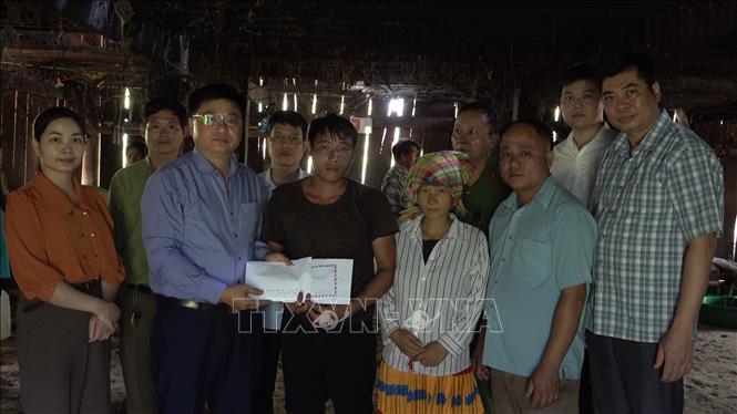 Lãnh đạo UBND huyện Bảo Lâm trao hỗ trợ cho gia đình có hai cháu bé bị tử vong do đuối nước. Ảnh: TTXVN phát