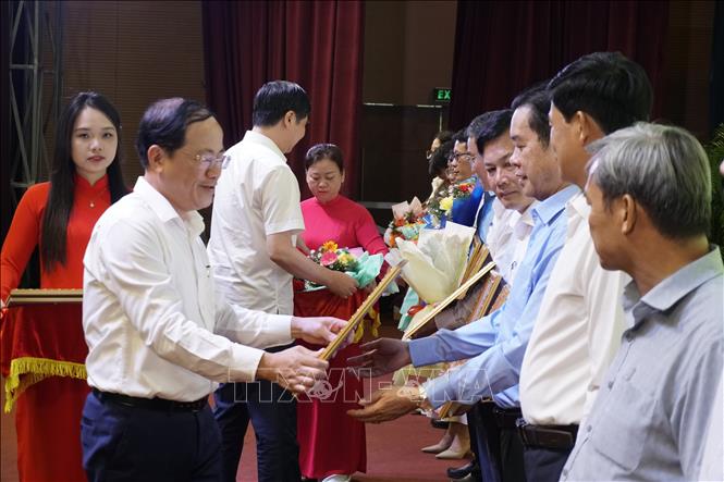 Ông Phạm Anh Tuấn, Chủ tịch UBND tỉnh Bình Định trao bằng khen cho các tập thể, cá nhân có thành tích xuất sắc. Ảnh: Đình Quân-TTXVN