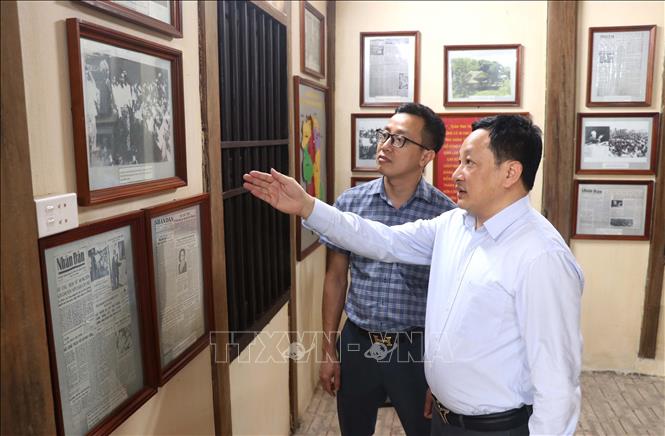 Ông Trương Văn Lành, Phó Trưởng ban Tuyên giáo và Dân vận Tỉnh ủy Hưng Yên (áo trắng) giới thiệu những bức ảnh Bác về thăm Hưng Yên tại  tại Nhà lưu niệm Bác Hồ, ở thành phố Hưng Yên. Ảnh: Đinh Văn Nhiều-TTXVN