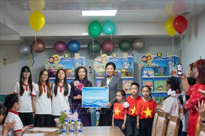 Phu nhân Ngô Phương Ly tặng sách cho lớp học tiếng Việt. Ảnh: TTXVN phát