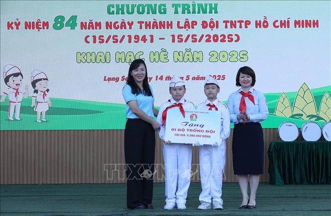 Phó Bí thư Tỉnh đoàn, Chủ tịch Hội đồng Đội tỉnh Lạng Sơn Lê Thùy Dung (phải) trao tặng 1 bộ trống Đội cho Liên đội Trường THCS Vĩnh Trại. Ảnh: Anh Tuấn – TTXVN