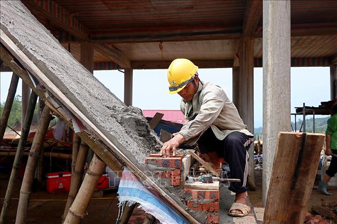 Công nhân xây dựng hoàn thiện hạng mục của một ngôi nhà tái định cư. Ảnh: Thanh Hải - TTXVN 