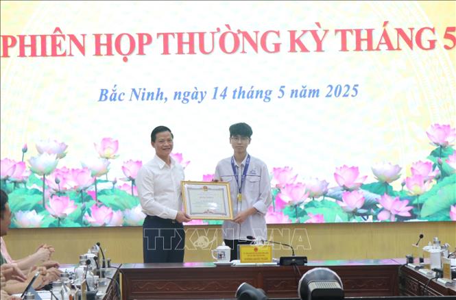 Chủ tịch UBND tỉnh Bắc Ninh Vương Quốc Tuấn trao Bằng khen tặng em Nguyễn Công Vinh. Ảnh: Thanh Thương- TTXVN