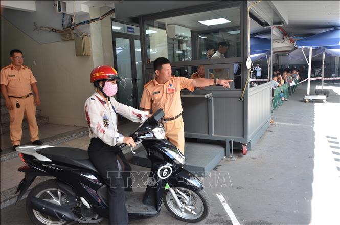 Công an hướng dẫn thí sinh phần thi thực hành lái xe mô tô. Ảnh: Linh Sơn-TTXVN