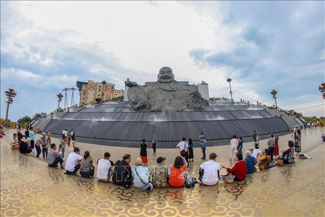 Du khách chiêm ngưỡng tượng Phật Di Lặc trên đỉnh núi Bà Đen. Ảnh: Giang Phương - TTXVN