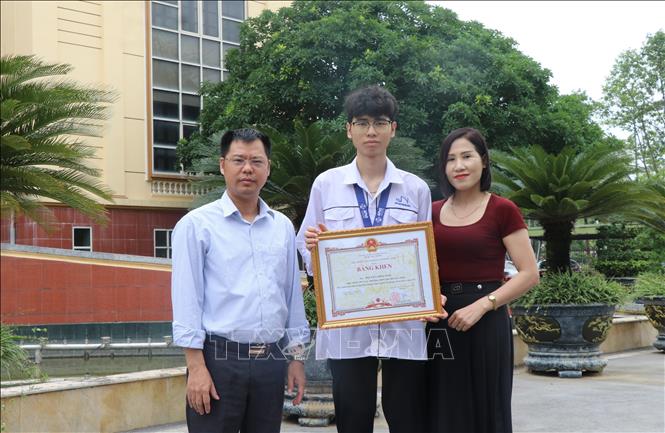 Thầy giáo Nguyễn Chí Trung, Tổ trưởng tổ Vật lý, trường THPT chuyên Bắc Ninh và chị Nguyễn Quỳnh Mai, mẹ của Nguyễn Công Vinh là những người luôn đồng hành với Vinh trong quá trình học tập. Ảnh: Thái Hùng - TTXVN
