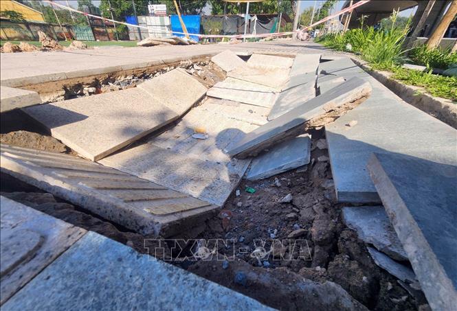 Các điểm sụt lún, gạch lát vỉa hè bong tróc, lộ phần đất đá bên dưới. Ảnh: Mạnh Linh - TTXVN