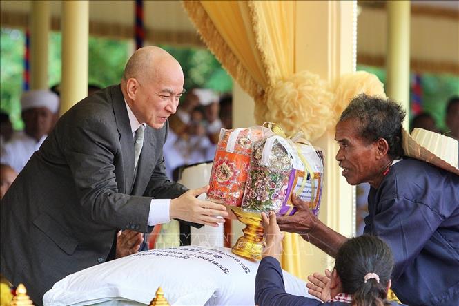Quốc vương Norodom Sihamoni tặng quà cho người dân địa phương. Ảnh: Quang Anh – PV TTXVN tại Campuchia