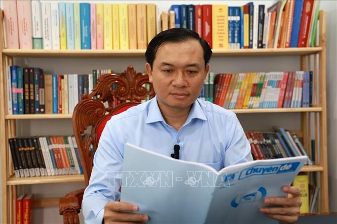 Ông Bùi Thanh Toàn, Bí thư Thành ủy Tuy Hòa tìm hiểu thông tin các chủ trương của Đảng về sắp xếp, tinh gọn bộ máy trên ấn phẩm của TTXVN. Ảnh: Xuân Triệu - TTXVN