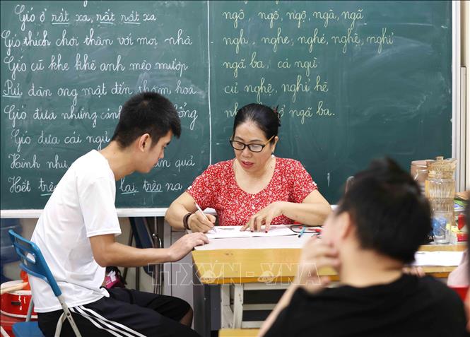 Cuối giờ học, bài tập viết của học sinh trong lớp sẽ được cô Thoa chấm điểm. Ảnh: Phương Hoa - TTXVN