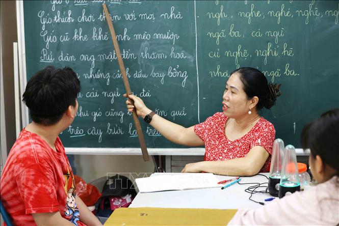 Cô Thoa dành thời gian cả tuần hướng dẫn các em đọc thành thạo một đoạn văn. Ảnh: Phương Hoa - TTXVN