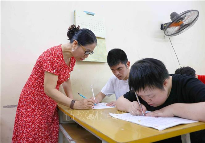 Cô Thoa kiên nhẫn dạy học trò tô bảng chữ cái. Ảnh: Phương Hoa - TTXVN