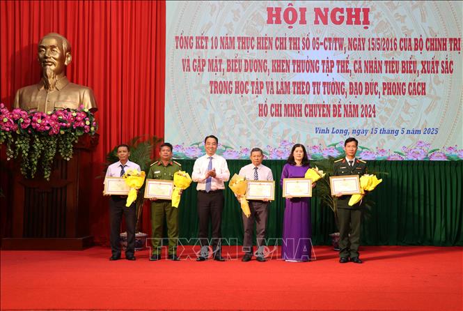 Chủ tịch UBND tỉnh Vĩnh Long Lữ Quang Ngời trao Bằng khen cho các tập thể có thành tích tiêu biểu, xuất sắc trong 10 năm thực hiện Chỉ thị số 05-CT/TW của Bộ Chính trị. Ảnh: Phạm Minh Tuấn-TTXVN.