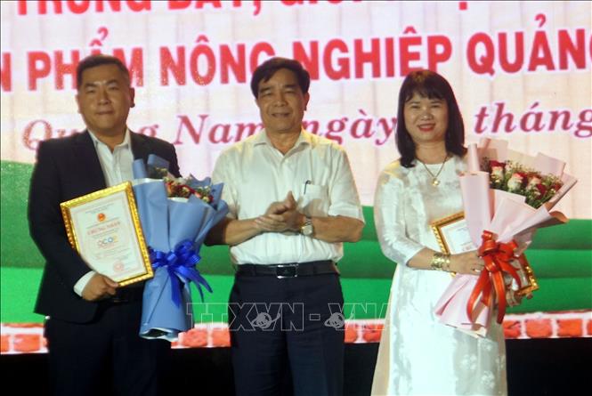 Ông Lê Văn Dũng, Chủ tịch Ủy ban nhân dân tỉnh Quảng Nam trao Bằng chứng nhận 2 sản phẩm 5 sao OCOP quốc gia cho 2 chủ thể của tỉnh Quảng Nam. Ảnh: Trịnh Bang Nhiệm - TTXVN