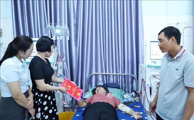 Lãnh đạo Ban Tuyên giáo và Dân vận Thị ủy Buôn Hồ, tỉnh Đắk Lắk trao “Sổ tiết kiệm Búa liềm vàng” hỗ trợ đảng viên bị bệnh hiểm nghèo. Ảnh: Hoài Thu - TTXVN