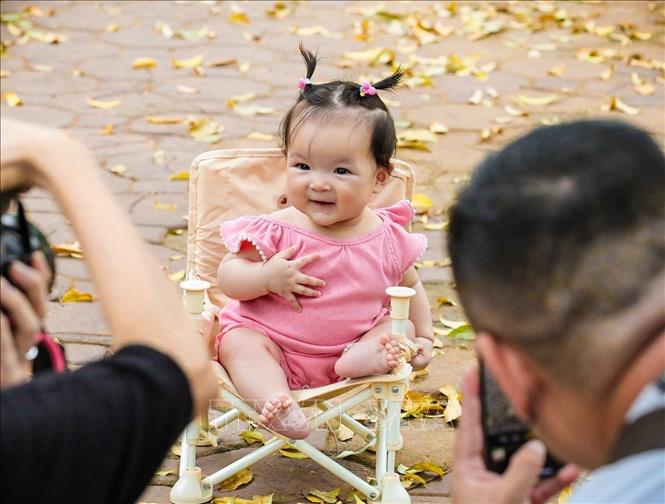 A baby gets her moment with Hanoi leaf-changing season. VNA Photo: Khánh Hoà