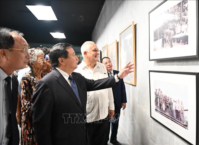 Đồng chí Nguyễn Xuân Thắng và các quan chức Cuba tham quan Triển lãm ảnh kỷ niệm 65 năm quan hệ song phương. Ảnh: Việt Hùng - PV TTXVN tại Cuba