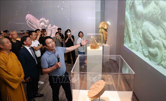 Đại biểu tham quan, nghe giới thiệu về nội dung trưng bày. Ảnh: Thanh Tùng - TTXVN