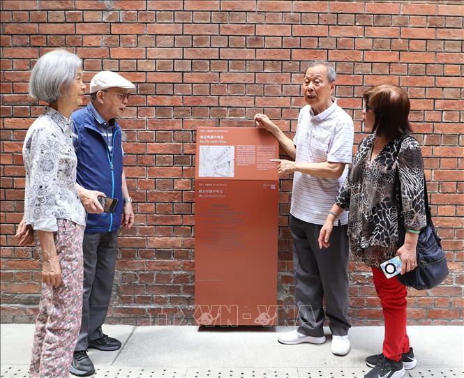 Ông Lý Minh Hán giới thiệu với mọi người về nội dung bia tưởng niệm Chủ tịch Hồ Chí Minh tại nhà tù Victoria thuộc Khu di tích Tai Kwun, Hong Kong hiện nay. Ảnh: Xuân Vịnh-PV TTXVN tại Hong Kong.