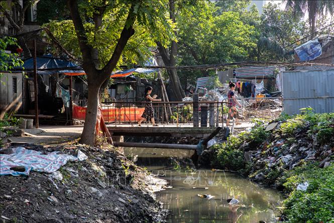 Rác thải sinh hoạt, nước thải khiến đoạn mương ngõ 162 Đội Cấn ô nhiễm nghiêm trọng, ảnh hưởng đến cuộc sống của người dân xung quanh (đoạn mương này kết nối với cống ngầm Phan Kế Bính). Ảnh: Lê Đông - TTXVN