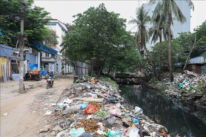 Trước cổng trường tiểu học Vạn Phúc (ngõ 194 Đội Cấn) ngổn ngang rác thải biến đoạn mương này ô nhiễm nghiêm trọng. Ảnh: Lê Đông - TTXVN