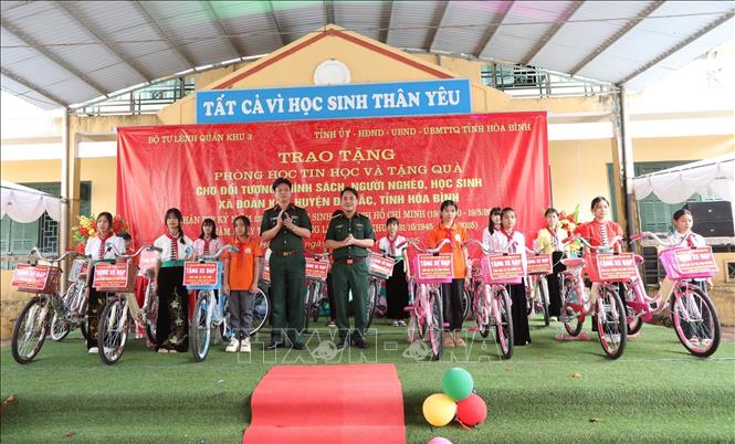 Đại diện Bộ Chỉ huy Quân sự tỉnh Hoà Bình tặng 15 xe đạp cho học sinh nghèo học giỏi trường Tiểu học và Trung học cơ sở Đoàn Kết, huyện Đà Bắc. Ảnh: Trọng Đạt - TTXVN